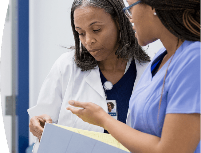 Two female medical professionals discussing the medical chart of a patient who may have been exposed to rabies.