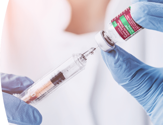 Gloved hands of a medical professional filling syringe from a vial of HyperRab® (rabies immune globulin [human])