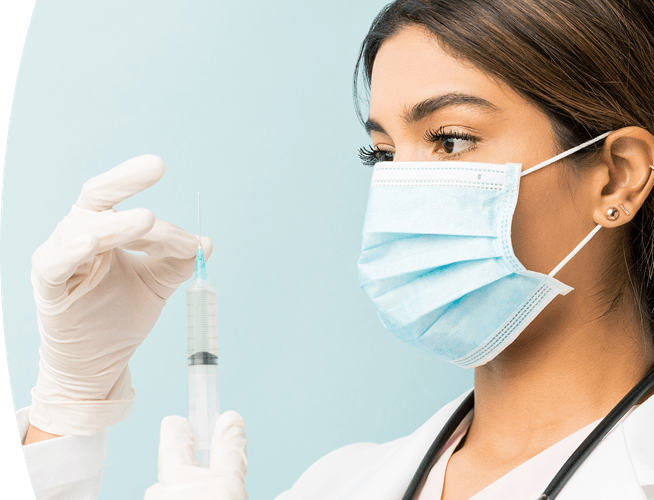 Female medical professional preparing a syringe for injection.