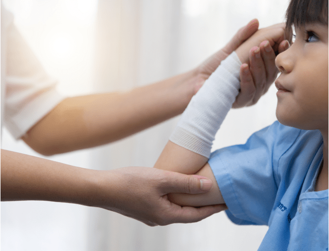 A medical professional treating a bandaged child who may have been wounded by a rabid animal.