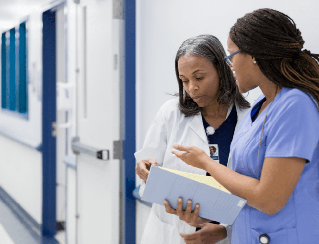 Two female medical professionals discussing the medical chart of a patient who may have been exposed to rabies.